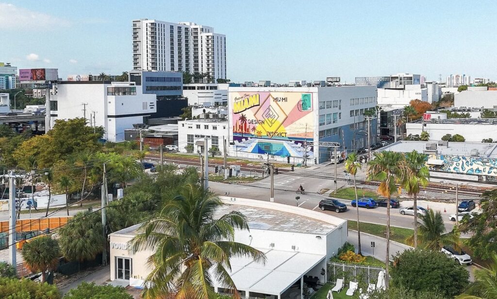 A monumental hand-painted mural titled “A Postcard to Rome” on a Miami Design District wall, fusing Fendi’s legacy with Miami flair
